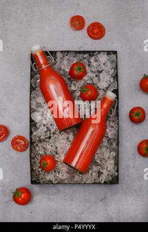 Ice-cooled homemade tomato juice in swing top bottles Stock Photo