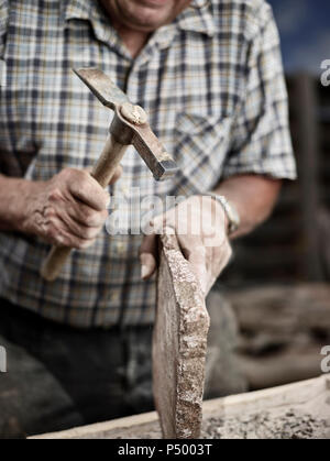 Stonemason working on stone with a hammer Stock Photo