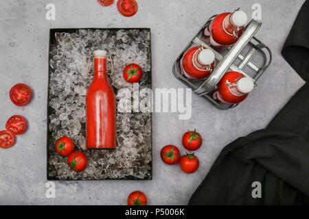 Ice-cooled homemade tomato juice in swing top bottle Stock Photo