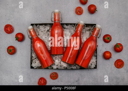Ice-cooled homemade tomato juice in swing top bottles Stock Photo