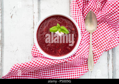 Beetroot soup in bowl on white wood Stock Photo