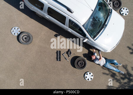 Mature man changing car tires, top view Stock Photo