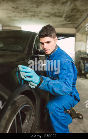 Man cleaning a car in a workshop Stock Photo