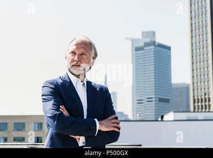 Serious mature businessman in the city looking around Stock Photo