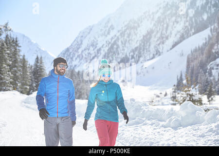 Couple walking in snow-covered landscape Stock Photo