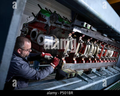 Worker in factory cleaning engine block Stock Photo