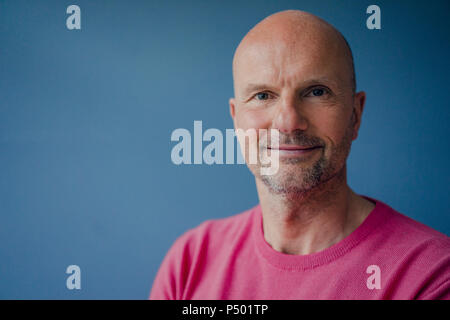 Portrait of smiling mature man wearing pink pullover Stock Photo