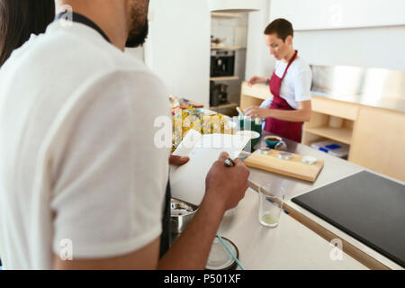 Close-up of man taking notes in a cooking workshop Stock Photo
