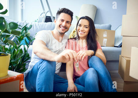 Portrait of happy couple moving in showing keys to new apartment Stock Photo