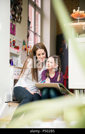 Mother and daughter painting together at home creating fun art projects ...