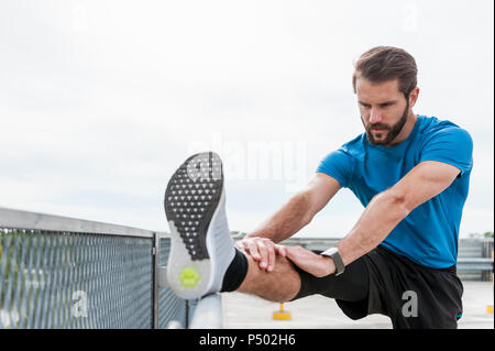 Man stetching on a parking level Stock Photo