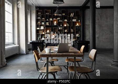 Laptop on table in loft Stock Photo