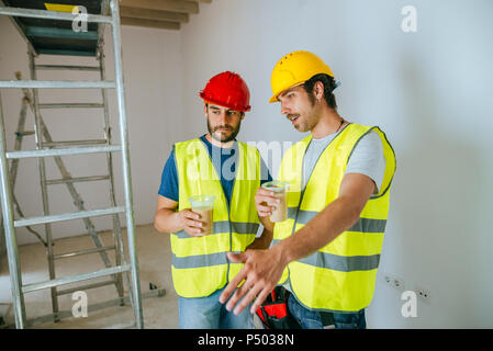 Two workers talking at work while drinking coffee Stock Photo