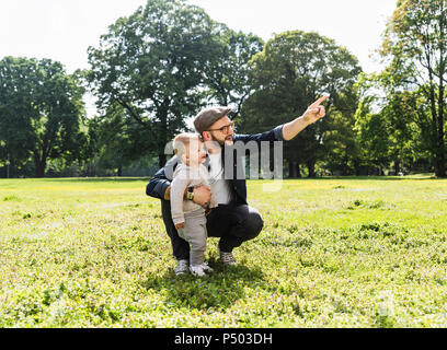 Father talking to son in a park Stock Photo