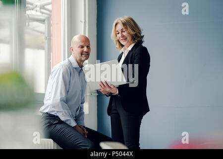 Businessman and businesswoman working together on laptop Stock Photo