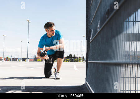 Man training with dumbells, doing one-armed plank Stock Photo