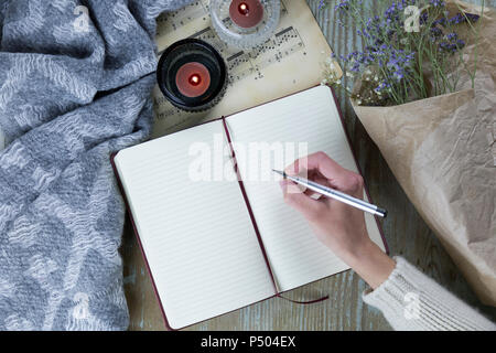 Hand of woman writing in notebook Stock Photo