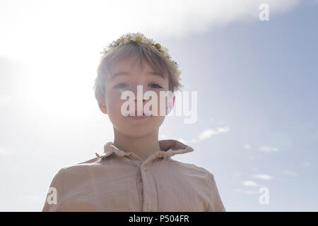 Portrait of boy wearing flowers at backlight Stock Photo