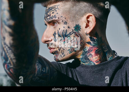 Portrait of tattooed young man outdoors Stock Photo