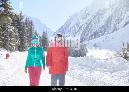 Couple walking in snow-covered landscape Stock Photo