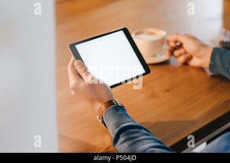 Close-up of man in a cafe holding tablet Stock Photo