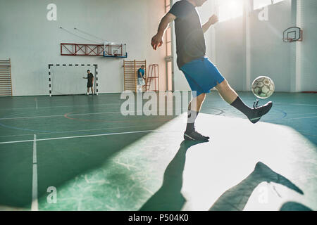 Indoor soccer player balancing the ball Stock Photo