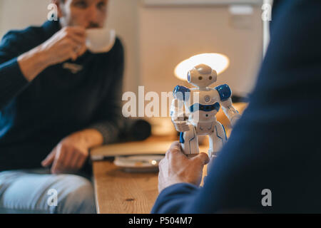 Two men and robot on table Stock Photo