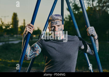 Portrait of tattooed young man outdoors Stock Photo