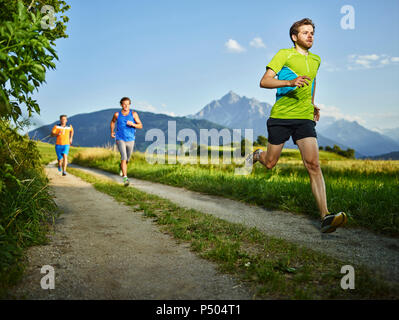 Athletes running on field path Stock Photo