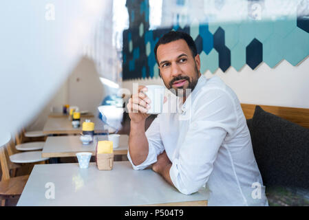 Man drinking coffee in a cafe Stock Photo