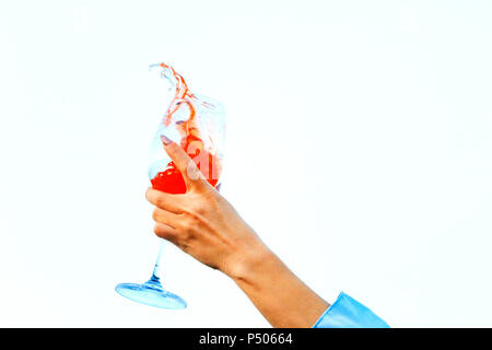 woman's hand holds a glass of spray of a colorful cocktail, drinks and tasting