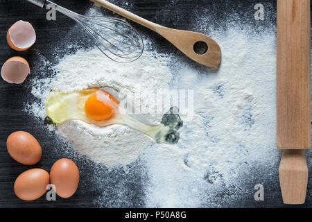 Baking background with a rolling pin, flour and raw eggs Stock Photo