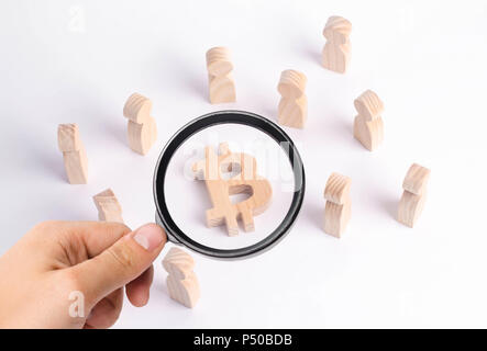 Wooden figures of people are standing near a bitcoin on a white background. Crypto currency, blockchain technology. The collapse and rise cost of bitc Stock Photo
