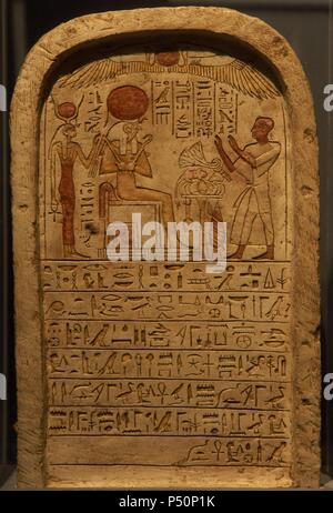 Egyptian Art. Stele depicting a priest making an offering to the god Ra (seated, with falcon's head and sun disk.) Behind him, the goddess Isis. 22nd Dynasty. Third Intermediate Period. Luxor Museum. Egypt. Stock Photo