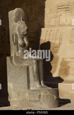 A granite seated statue of the lioness goddess Sekhmet at Medinet Habu ...
