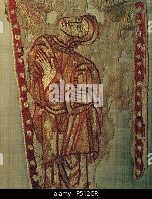 ARTE ROMANICO. S. XI-XII. PENDON DE SAN ODON DE CLUNY (1095-1122). Tejido de lino color crudo bordado a base de sedas policromadas. 'FIGURA DE ORANTE CON EL EVANGELIO Y LA MANO DERECHA EN POSICION DE ORACION'. Procede de un relicario del altar de San Odón de Cluny de la Seu d'Urgell (provincia de LLeida). Museo Textil y de la Indumentaria. Barcelona. Cataluña. Stock Photo