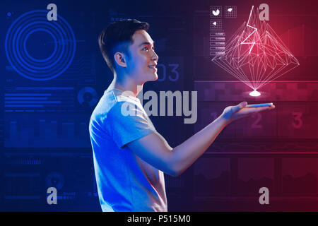 Emotional young man feeling impressed while making a beautiful hologram Stock Photo