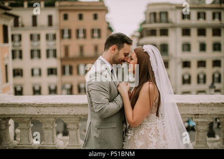 Young attractive newly married couple walking and posing in Rome with  beautiful and ancient architecture on the background on their wedding day  Stock Photo - Alamy