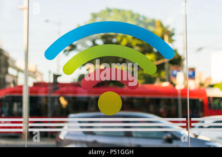 Colorful WI-FI zone sign with cars and bus in background. Sign have blue, green, red, yellow color. Stock Photo