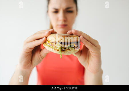 A young girl shows that she does not like a burger. Conceptual image of