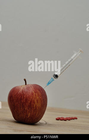 An injection needle stuck into an apple Stock Photo - Alamy