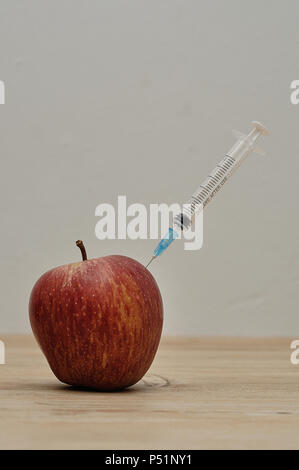 An injection needle stuck into an apple Stock Photo - Alamy