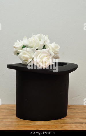 A bunch of white roses in a magicians hat Stock Photo