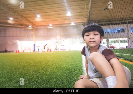 Little boy sitting in soccer sport train field Stock Photo