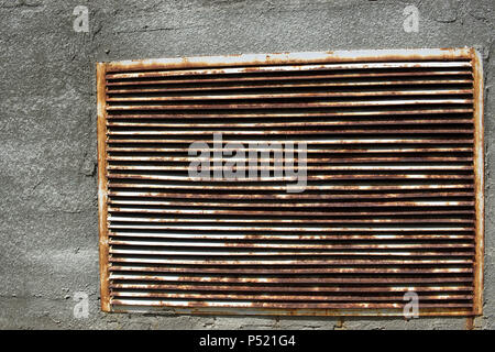 A brick wall with a rusty iron grille in it Stock Photo