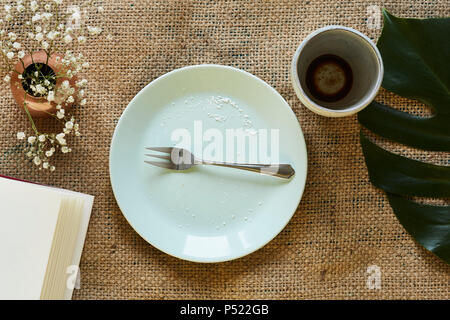 empty plate with fork in creative table setting modern coffee house Stock Photo