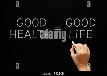 Hand writing Good Health Equals Good Life with white chalk on blackboard. Stock Photo