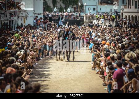 Ciutadella, Spain. 24 June, 2018:  Two 'caixers' (horse riders) gallop together with their arms entwined during the training session for the 'Jocs des Pla' (medieval tournament) during the traditional 'Sant Joan' (Saint John) festival in Ciutadella de Menorca Credit: Matthias Oesterle/Alamy Live News Stock Photo