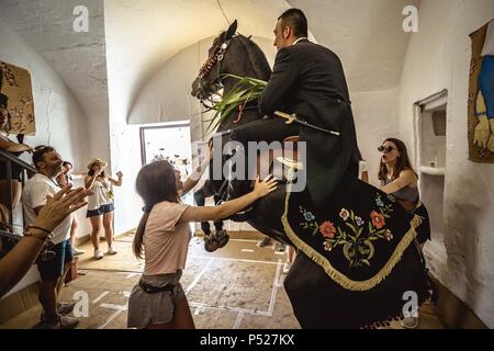 Ciutadella, Spain. 24 June, 2018:  A 'caixer' (horse rider) rears up on his horse in a private house during the 'Caragol de Santa Clara' during the traditional 'Sant Joan' (Saint John) festival in Ciutadella de Menorca Credit: Matthias Oesterle/Alamy Live News Stock Photo