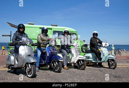 Edinburgh Portobello Beach, Scotland 24th June 2018. Crowds flock to the beach to enjoy the 23 degrees temperatures. These 4 Vespa scooter riders traveled from East end of Glasgow Stock Photo